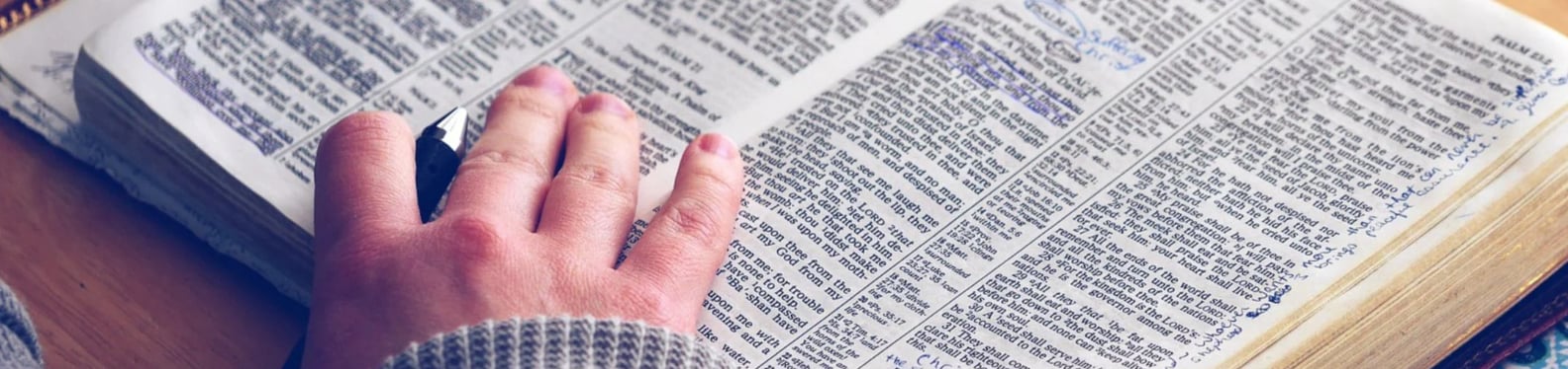 Open Bible - Hand with pen
